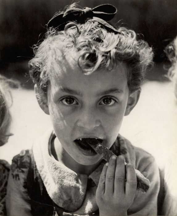 Девочка ест кусок хлеба в летнем лагере TOZ в Отвоцке, недалеко от Варшавы